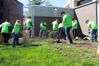 Volunteers from PECO help clean the grounds of Overbrook Park Library. 